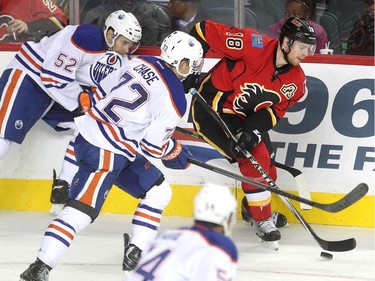 Calgary Flames centre Matt Stajan tried to keep the puck from Edmonton Oilers players centre Phil McRae, left, and centre Greg Chase during the third period of a split squad preseason NHL game at the Scotiabank Saddledome on September 21, 2015. The Flames lost 3-1 to the Oilers.