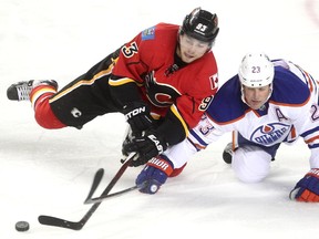 Calgary Flames centre Sam Bennett stretches for the puck while falling to the ice with Edmonton Oilers left winger Matt Hendricks during a split squad NHL pre-season game earlier this month.