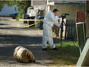 Lethbridge Regional Police Const. Jason Darby records evidence on Sunday, Sept. 20, 2015, while investigating the homicide of a 29-year-old man, who was found dead inside a residence in the 500 block of 19 Street North, the day before.