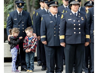 Firefighter Craig Bilodeau with his five- year-old twins Brooklyn, left and Bowen during the Firefighters Memorial ceremony at the Police Officers and Firefighters Tribute Plaza in front of the City Hall.