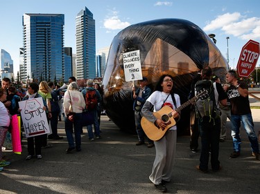 A small group of protesters gather around a "carbon bubble" at the Globe and Mail leaders debate in Calgary on Thursday, Sept. 17, 2015.