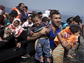 Syrian refugees arrive aboard a dinghy after crossing from Turkey to the island of Lesbos, Greece. Reader says such refugees wouldn't place a burden on Canada's economy.