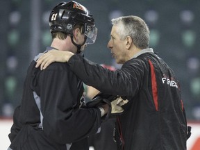 Calgary Flames head coach Bob Hartley talks with defenceman Brett Kulak during a Anaheim Ducks playoff series practice at the Saddledome in Calgary, on May 6, 2015..
