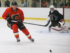 Michael Ferland, left, takes off towards the boards to collect a puck during Calgary Flames practice at WinSport on Sunday. The budding power forward, who has already achieved fame for last spring's wrecking ball playoff performance, insists he's just trying to make the team.