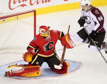 Calgary Flames goalie Jonas Hiller, left, blocks a shot from Colorado Avalanche Mikko Rantanen during pre-season action at the Scotiabank Saddledome.