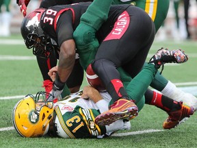 Charleston Hughes sacks Eskimos quarterback Mike Reilly during the Labour Day Classic. Calgary extinguished the spark Edmonton's starting QB had ignited when he entered that game midway through, but in Saturday's rematch, they're expecting Reilly to play right from the start.