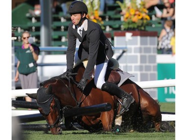 Steve Guerdat and Corbinian crash through a gate during the $210,000 Tourmaline Oil Cup at the Spruce Meadows Masters on Friday September 11, 2015.
