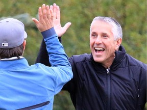 Calgary Flames head coach Bob Hartley congratulates a teammate on his shot during the Calgary Flames Celebrity Charity Golf Classic at Country Hills Golf Club on Tuesday.
