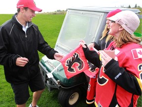 Johnny Gaudreau signs autographs for fans Stephanie Servetnyk and Hazel Forman while playing in the Calgary Flames Celebrity Charity Golf Classic at Country Hills Golf Club on Tuesday.