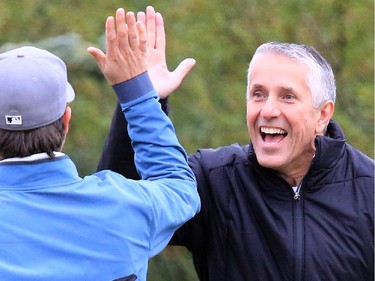 Head coach Bob Hartley congratulates a teammate on his shot during the Calgary Flames Charity Golf Tournament at the Country Hills Golf Course on Tuesday September 15, 2015.