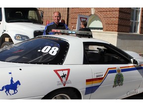 Gord Buck, a police officer and the president of YEILD association, with the 2000 Camaro drag car the group uses for driving safety education.