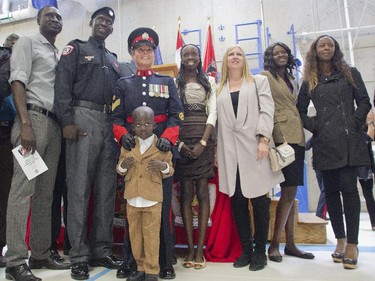 Stephen Deng who came to Canada from war torn Sudan, has his picture taken with family and friends, including his mentor Sergeant Clare Smart after graduating with the Calgary Police Auxilliary Cadet Program Friday June 12, 2015 at HMS Tecumseh.