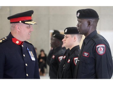 Stephen Deng who came to Canada from war torn Sudan graduates  with the Calgary Police Auxilliary Cadet Program Friday June 12, 2015 at HMS Tecumseh. He is being inspected by Police Chief Paul Cook.