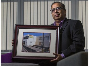 Dr. Anil Jain, CFO of Advanced Orthomolecular Research, holds a photo of the hospital he helped start and still helps run in India, while at his Calgary office, on Sept. 23, 2015.