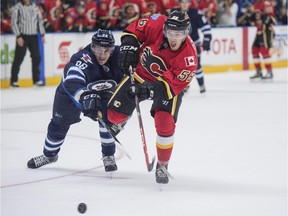 Ryan Lomberg of the Calgary Flames, gets a shot away while being bothered by Aaron Harstad of the Winnipeg Jets during their game at the YoungStars Classic in Penticton last Friday.