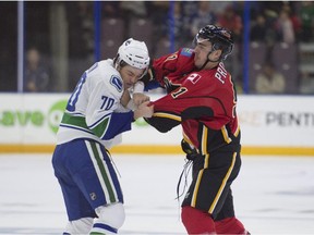 Jonathan Martin of the Vancouver Canucks prospects takes a shot on the chin from Julien Proulx of the Calgary Flames prospects during their Monday game in Penticton, B.C.