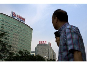 Buildings owned by state-owned companies CNOOC and Sinopec rise in Beijing. A new survey shows Albertans are less supportive of Chinese investment in the province.