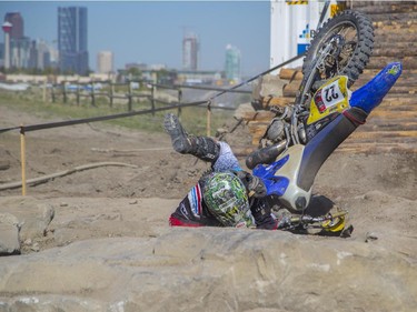 Mitch Brown, of the amateur category, takes a tumble as he competes in Canada's only Urban Endurocross Challenge, the Red Bull Rocks & Logs at Wild Rose MX park in Calgary, on September 12, 2015.