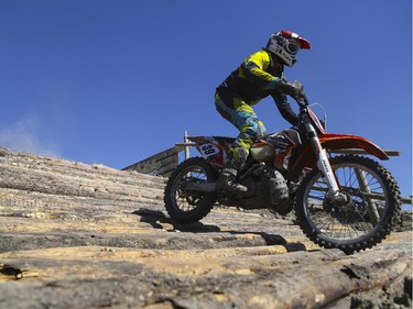 Clinton Boos, of the amateur category, races down some logs as he competes in Canada's only Urban Endurocross Challenge, the Red Bull Rocks & Logs at Wild Rose MX park in Calgary, on September 12, 2015.