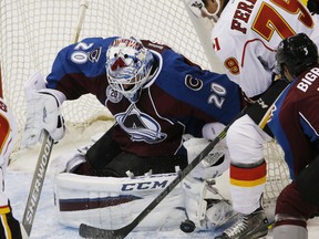 Colorado Avalanche goalie Reto Berra, left, stops a shot by Calgary Flames left winger Micheal Ferland during a pre-season game in Denver on Thursday night.