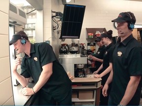 Sidney Crosby and Nathan MacKinnontry their hands at running a Tim Horton’s drive-thru window.