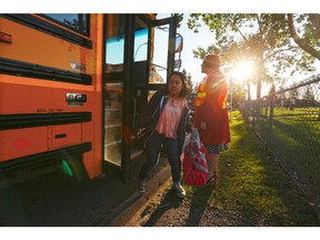 Students arrive by bus on the first day of school at St. Stephen School (K-9) on Tuesday September 1, 2015.