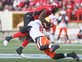 Calgary Stampeders wide receiver Jeff Fuller, top, is tackled by B.C. Lions linebacker Bo Lokombo during Friday's game. Fuller had a circus catch negated by a puzzling offensive pass interference call.