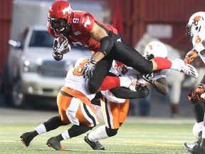Calgary Stampeders running back Jon Cornish sails over the the B.C. Lions opposition at McMahon Stadium in Calgary on Friday, Sept. 18, 2015. The Calgary Stampeders beat the B.C. Lions 35-23.