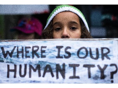 Kalina Idris holds up a sign protesting the plight of Syrian refugees at City Hall in Calgary on Friday, Sept. 4, 2015.