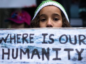 Kalina Idris holds up a sign protesting the plight of Syrian refugees at City Hall in Calgary on Friday, Sept. 4, 2015.