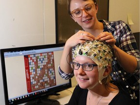 Sophia van Hees, the lead researcher in a Scrabble brain study in Calgary, checks the leads on one of the participants, Jessie Hart, in Calgary on September 29, 2015.