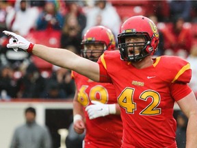 Dinos player Micah Teitz, centre, lets out a cheer after a successful play at McMahon Stadium in Calgary on Friday, Sept. 4, 2015. The University of Calgary Dinos football team hosted the University of British Columbia Thunderbirds in the home opening game of the 2015 season.