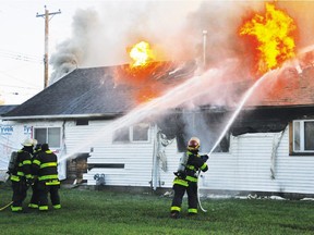 Firefighters battle a blaze at a Vulcan house Monday, Sept. 28, 2015. Two people were later found dead in the residence.