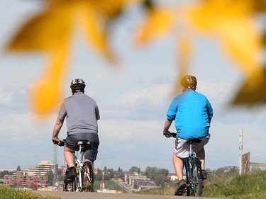 Cyclists pass early season autumn colours on the pathway above Max Bell Arena Tuesday September 1, 2015. (Ted Rhodes/Calgary Herald)