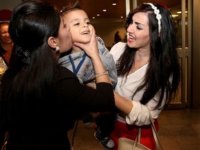 Samer Odisho, right, greets her nephew Leonardo Odisho, 3, at the Calgary International Airport after he arrived from Syria with his parents.