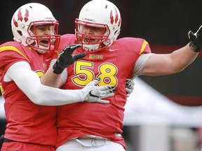 U of C Dino's Denzel Radford, left, celebrates a touchdown with teammate Ryan Sceviour during game action against the U of S Huskies at McMahon Stadium in Calgary, on October 3, 2015.