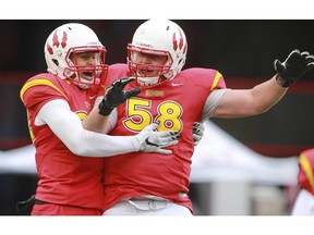 FILE: U of C Dino's Denzel Radford, left, celebrates a touchdown with teammate Ryan Sceviour during game action against the U of S Huskies at McMahon Stadium in Calgary, on October 3, 2015.