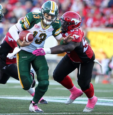 Calgary Stampeders Micah Johnson, right, runs to tackle Edmonton Eskimos quarterback Mike Reilly during their game at McMahon Stadium in Calgary on October 10, 2015 .