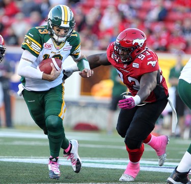 Calgary Stampeders Micah Johnson, right, runs to tackle Edmonton Eskimos quarterback Mike Reilly during their game at McMahon Stadium in Calgary on October 10, 2015 .