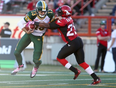 Calgary stampeders Keon Raymond, right, tries to get the ball from Edmonton Eskimos quarterback Mike Reilly during their game at McMahon Stadium in Calgary on October 10, 2015 .