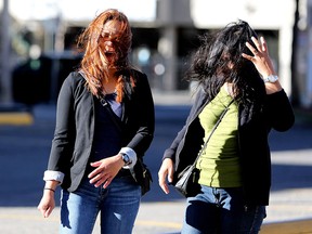 CALGARY.;  OCTOBER 11, 2015  -- A gust of wind blows Edlyn Estrella's, left, and Elma Valvag's hair as they walk to church in downtown Calgary on October 11, 2015