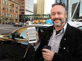 Calgary philanthropist Brett Wilson showed off the Uber app after he climbed out of the back of an Uber vehicle after catching a ride downtown as rider zero during the morning rush hour on Oct. 15, 2015.