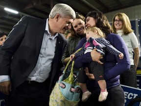 Conservative Leader Stephen Harper, left, talks with mothers and their children after speaking during a campaign stop in Saskatoon, Sask, on Wednesday, October 7, 2015. THE CANADIAN PRESS/Nathan Denette