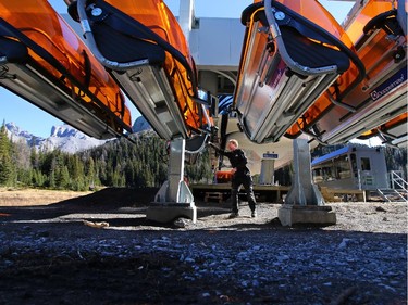 Sunshine Village's lift manager Kristian Haagaard moves the new heated quad chairs off the line on the resort's new Teepee Town XL chair. The quad chair lift is the first in Canada with heated seats. At European ski resorts lifts with orange tinted bubbles signify that the lift has heated seats. Each night the chairs come off the cable and are stored on a rack at the base to help protect them.