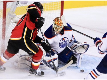 Gavin Young, Calgary Herald CALGARY, AB: OCTOBER 17, 2015 - Calgary Flames'    Dougie Hamilton fights for the puck in front of Edmonton Oilers goaltender Cam Talbot this first period break away at the Scotiabank Saddledome on Saturday October 17, 2015. (Gavin Young/Calgary Herald) (For City section story by Scott Cruikshank) Trax# 00069395A