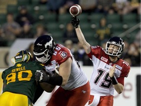 Calgary Stampeders quarterback Bo Levi Mitchell makes a throw as Dan Federkeil and Edmonton Eskimos' Almondo Sewell battle in front during the last meeting between the provincial rivals, on Sept. 12 in Edmonton.
