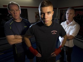Undefeated Polish boxer Łukasz Wierzbicki, centre, with his trainer Doug Harder, left, and promoter Michael Short, stands in the ring at Bowmont Boxing Club prior to their Dekada Premier Fight Night card at the Genesis Centre in Calgary on Friday.