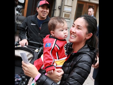 Calgary Flames fan Connie Vu smiles with daughter Audrey after winning a pair of tickets to the first regulars season Flames game. Forward Johnny Gaudreau also drove a Zamboni down Centre Street in downtown Calgary on Tuesday as part of a promotion with Sport Chek to kick off the start of the season