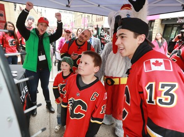 Calgary Flames forward Johnny Gaudreau celebrates with the Courtney family as the spin a wheel for free tickets in downtown Calgary on Tuesday as part of a promotion with Sport Chek to kick off the start of regular season hockey.