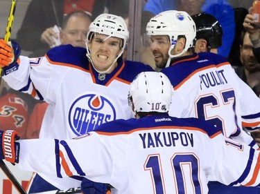 The Edmonton Oilers' Conner McDavid, left celebrates scoring with Nail Yakupov and Benoit Pouliot during the second period of NHL action at the Scotiabank Saddledome Saturday October 17, 2015.